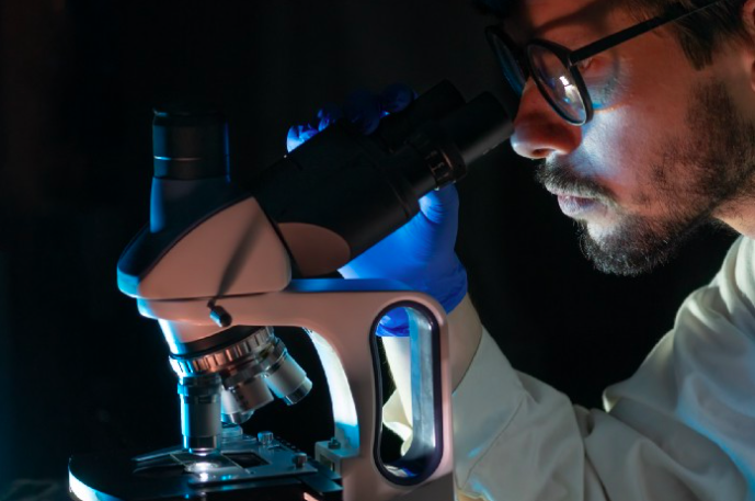 man looking through microscope, as a concept of building a website or app