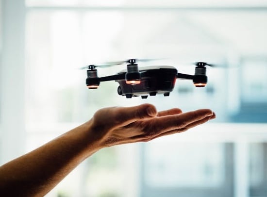 Close-up of a drone flying over a man's open palm